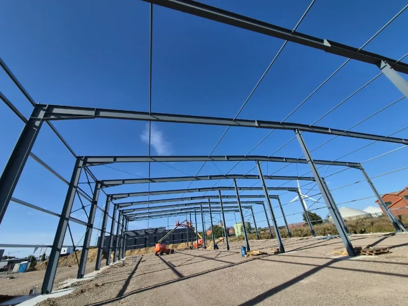 Stahlhallen-Tragwerk im Rohbau unter blauem Himmel